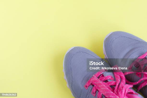 Grey Sneakers With Pink Laces On Light Yellow Background Stock Photo - Download Image Now