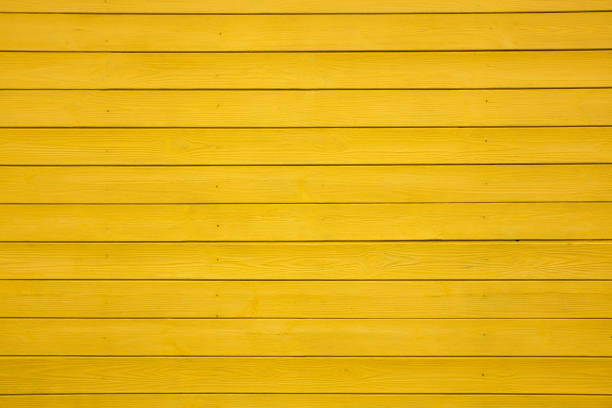 Wooden boards painted with yellow paint. Background Texture