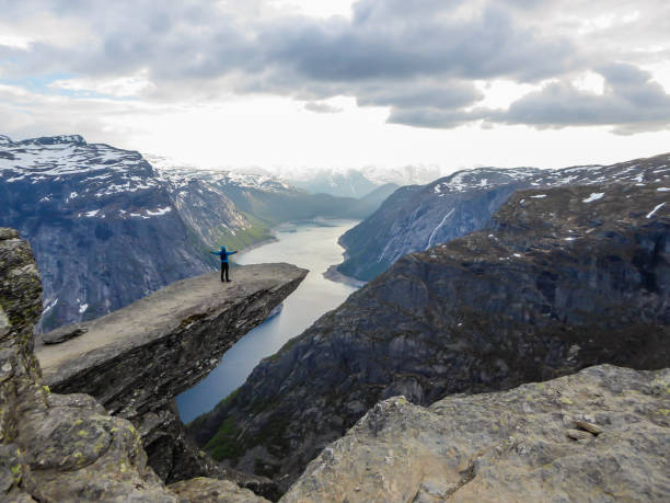 istock Norway - Young man standing at the edge of Trolltunga 1148631137
