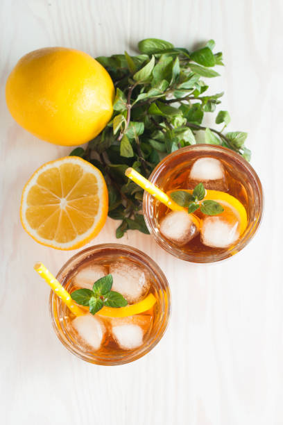 istock Refreshing citrus lemonade, summer drink. Ice tea with fresh lemon and mint on wooden background. Refreshment beverage concept. 1148632643