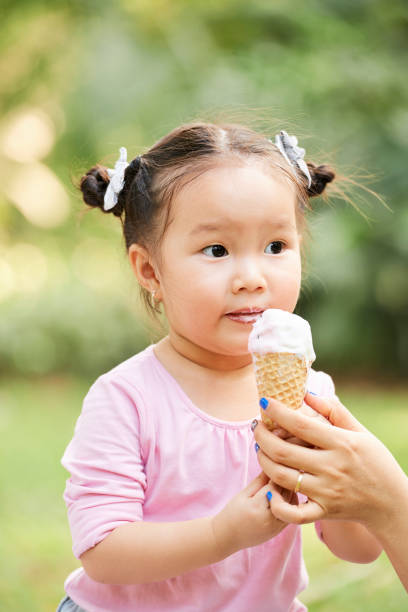 istock Adorable little girl with ice cream 1148633697
