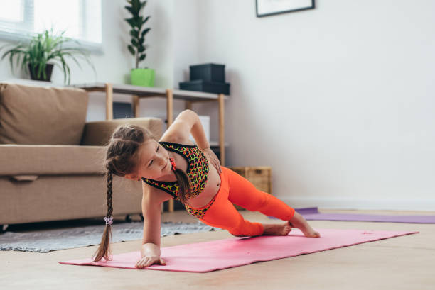 Little girl doing plank exercise at home. Little girl doing plank exercise at home child core muscles stock pictures, royalty-free photos & images
