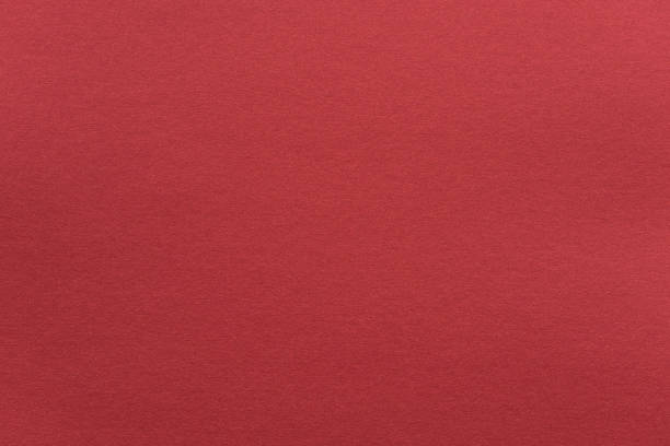 Abstract red glossy paper texture background or backdrop. Empty wrapping paper or shiny paperboard for decorative design element. Grainy surface for Christmas holiday or Chinese new year concept