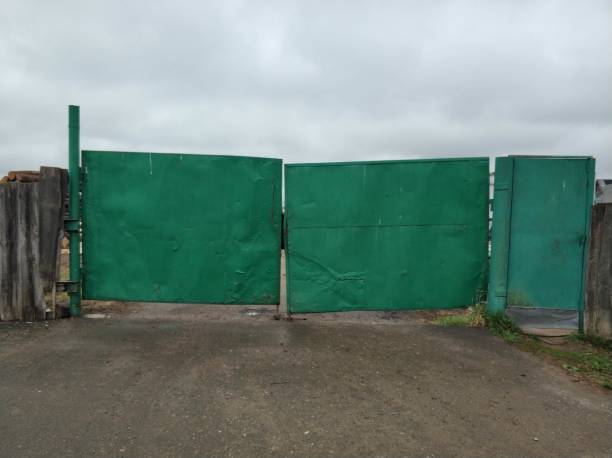 istock Green iron gates. Green background. Grey sky. 1148635464