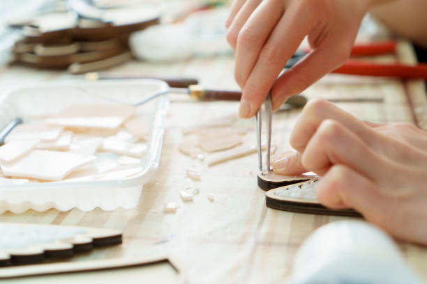 o artista fêmea das mãos recolhe o fim do mosaico acima - mosaic human hand craft artist - fotografias e filmes do acervo