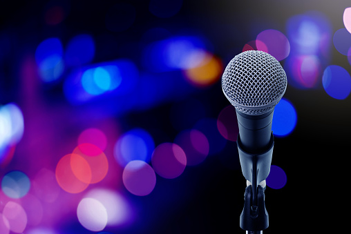 Close up microphone  on stage in concert hall or conference ball room. Let's sing