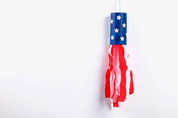 Diy windsocks 4th July toilet sleeve, crepe paper colors American flag, red, blue, white. Gift idea, decor July 4, USA Independence Day. Step by step. Top view. Process kid children craft. Workshop