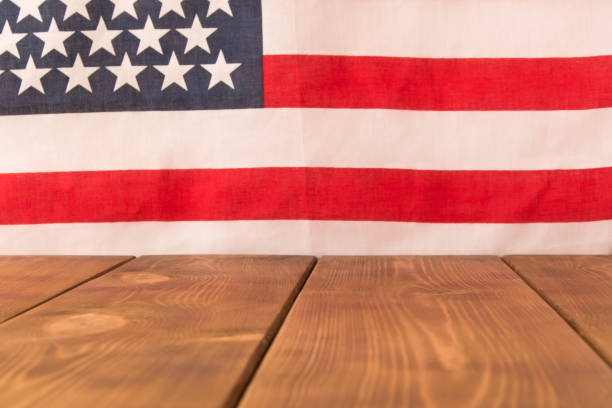 istock Wooden table and American flag in the background. Selective focus. 1148639821