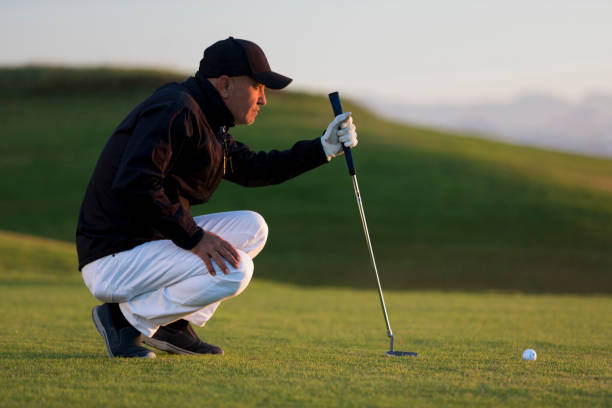 ショットを決定するための穴に探しているゴルフ選手-リンクスゴルフ - sports flag flag shadow golf flag ストックフォトと画像