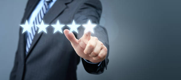 бизнесмен, указывающий на символ рейтинга пятизвездочных сервисов - star shape service perfection gold стоковые фото и изображения