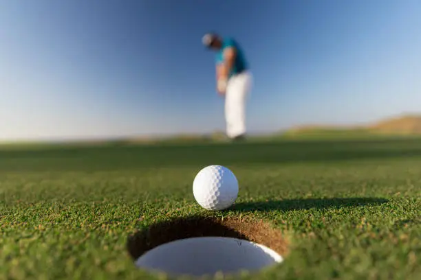Photo of Golf ball entering the hole after successful stroke - Close up -  Links Golf