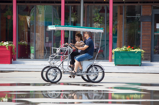 Russia, Moscow, July 29, 2018. Sokolniki Park. People riding a four-wheeled bike