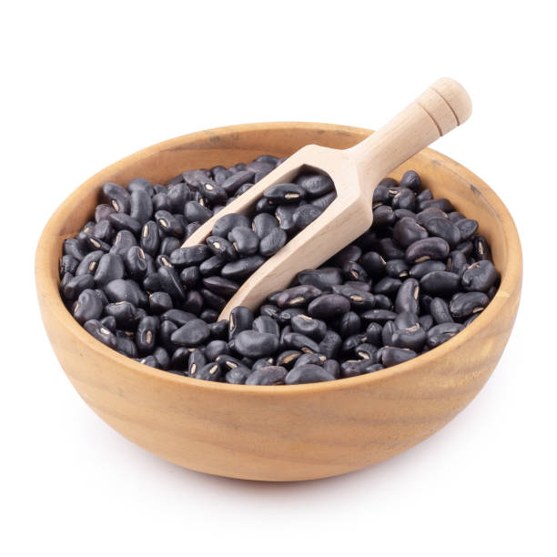 istock Black bean in a wooden bowl isolated on white background 1148648270