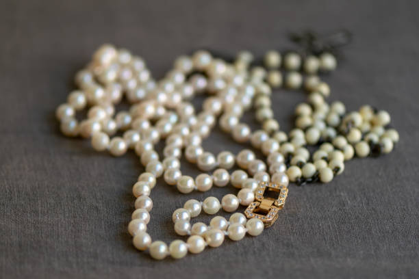 istock White rosary and pearl necklace on linen fabric. 1148650068