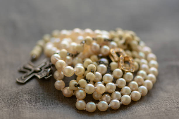 istock White rosary and pearl necklace on linen fabric. 1148650088