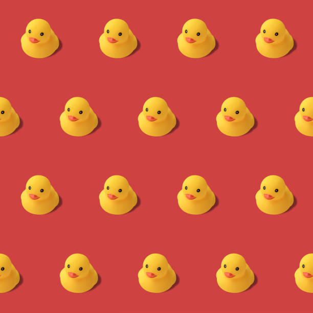 repeatable pattern of yellow rubber duck on red background Modern style. creative photography.