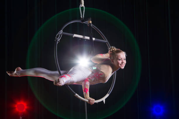 interpreta a una actriz de circo. gimnasta aérea de circo en el aro. acrobacias. adolescente realiza un truco acrobático en el aire - acróbata circo fotografías e imágenes de stock