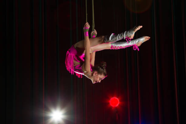 istock Circus artist acrobat performance. The girl performs acrobatic elements in the air. Circus gymnast on the stage 1148651302