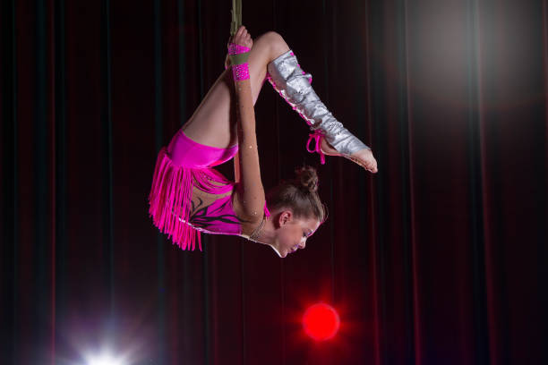 istock Circus artist acrobat performance. The girl performs acrobatic elements in the air. Circus gymnast on the stage 1148651309