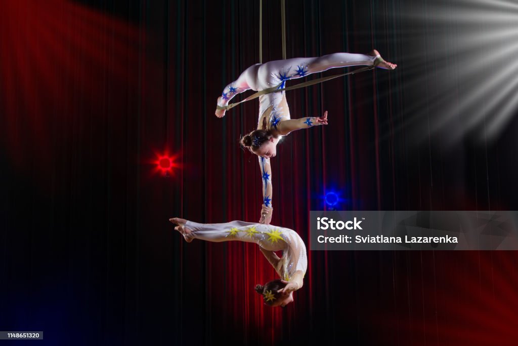 Actuación de actriz de circo acróbata. Dos chicas realizan elementos acrobáticos en el aire. - Foto de stock de Circo libre de derechos