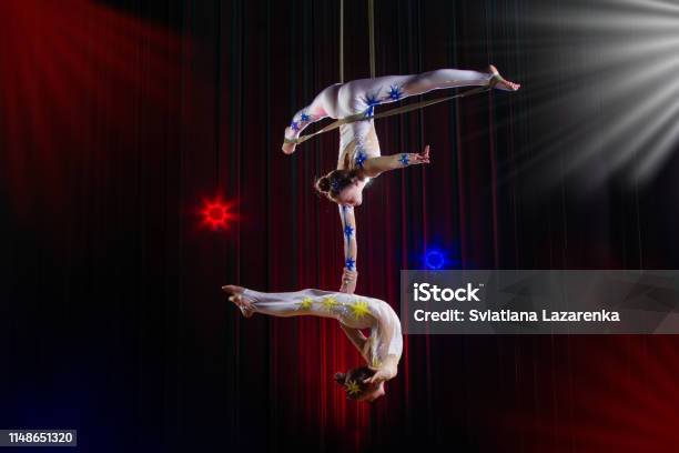 Actuación De Actriz De Circo Acróbata Dos Chicas Realizan Elementos Acrobáticos En El Aire Foto de stock y más banco de imágenes de Circo