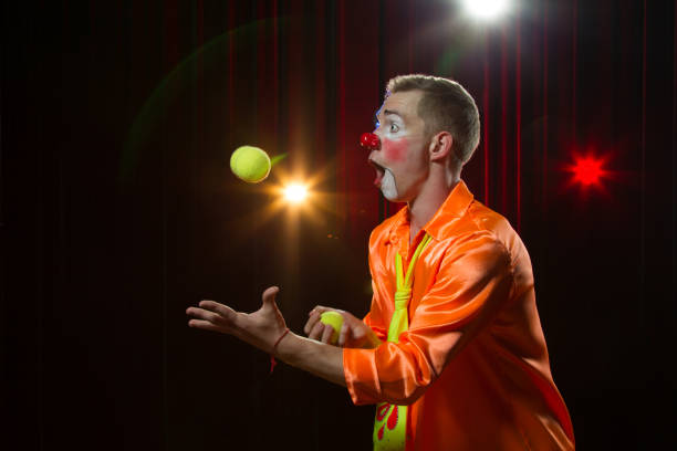 istock Circus clown performs number. Clown man juggles 1148651371