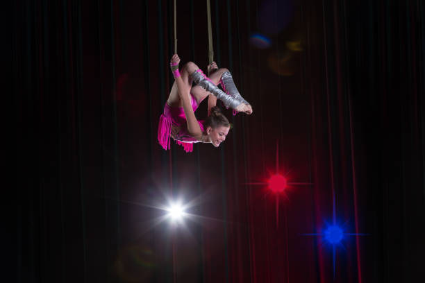 istock Circus artist acrobat performance. The girl performs acrobatic elements in the air. Circus gymnast on the stage 1148651731
