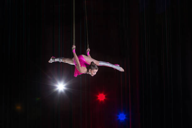 istock Circus artist acrobat performance. The girl performs acrobatic elements in the air. Circus gymnast on the stage 1148651742