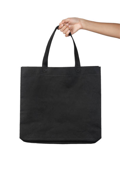 istock Hand holding blank black fabric canvas bag isolated on white background with clipping path, eco concept. 1148651786