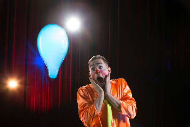 istock Circus lown performs number. A man in a clown outfit with a balloon 1148651799