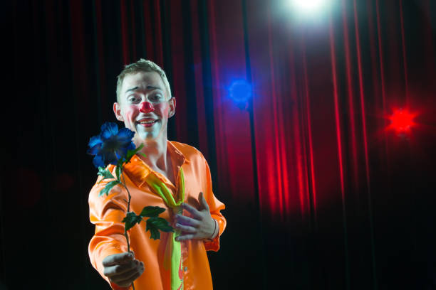 istock Circus clown performs number. A man in a clown dress with a flower 1148651814