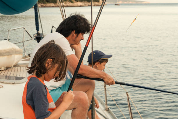 istock Father fishing with sons on sailboat 1148653395