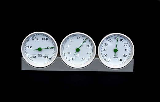 Barometer, thermometer, hygrometer isolated on black background.