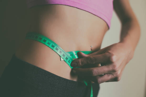istock Woman measuring her thin waist 1148661399