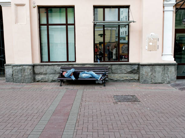 Moscow, Russia - May 03, 2019: a homeless man is sleeping on the bench on Arbat street