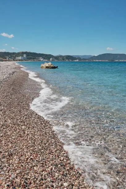 Rocky beach with hotels far away in the background