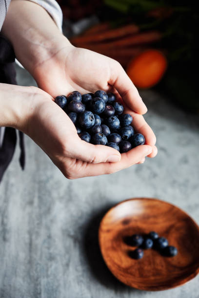 istock Woman's hands full of blueberries 1148671899