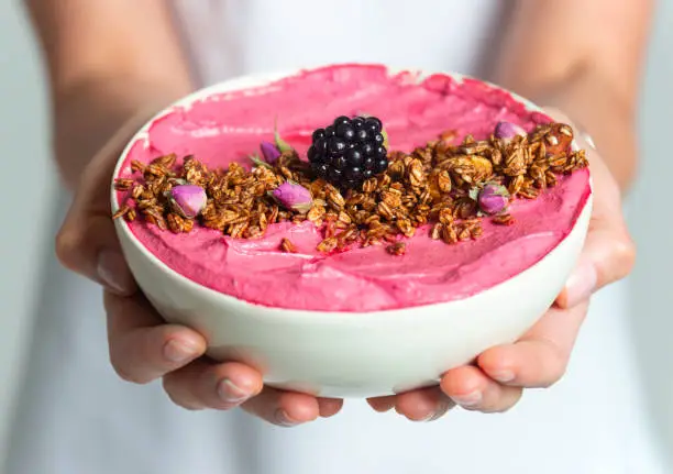 Woman giving smoothie bowl.