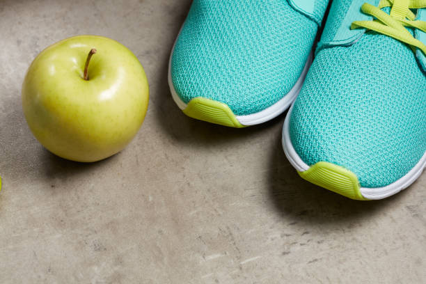 istock Closeup on green apple and sneakers on floor 1148677250