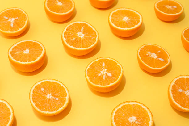 istock Orange juicy oranges split in half on yellow 1148678256