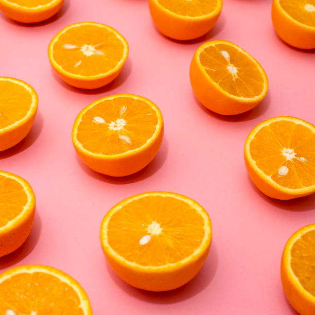 istock Orange juicy oranges split in half on pink 1148678351