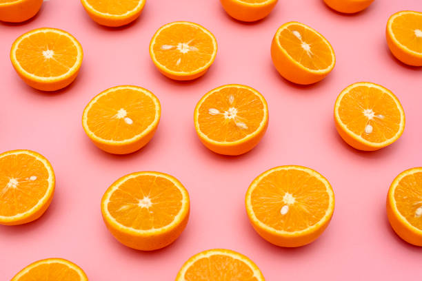 istock Orange juicy oranges split in half on pink 1148678375