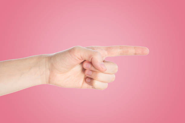 istock Pointing finger on a pink background. Hand show direction gesture, close up 1148678641