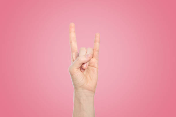 istock Hand show rock gesture on a pink background, close up. 1148678646