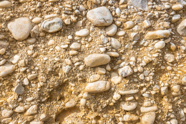 close-up of exposed rock boulders in clay and sandy soil cross section