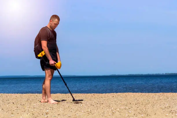 man with a metal detector on the beach