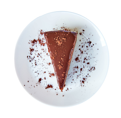 Traditional Austrian sachertorte on round plate on white background with Choco Shavings, Prepared on White Plate.  View from above. Isolated.