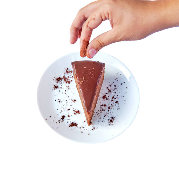 istock Traditional Austrian sachertorte on round plate on white background with Choco Shavings, Prepared on White Plate.  View from above with Human Hand. Isolated. 1148688875