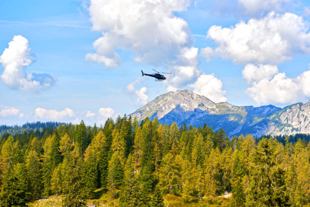 helicopter flies in the mountains on a sunny day