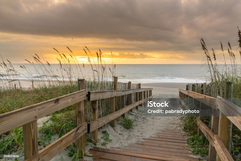 Boardwalk Leading to the Beach at Sunrise Sunrise along boardwalk over a sand dune in Myrtle Beach, South Carolina Beach Stock Photo